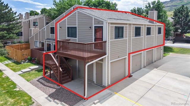 18274 W 58th Pl Unit 37, Golden, CO 80403 - view of front of property featuring a deck, an attached garage, driveway, stairway, and a chimney
