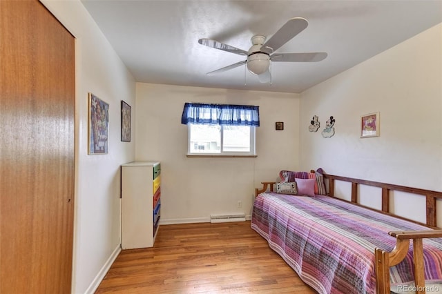 bedroom featuring a baseboard radiator, ceiling fan, and light hardwood / wood-style floors