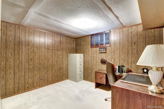 office featuring light carpet, a textured ceiling, and wood walls