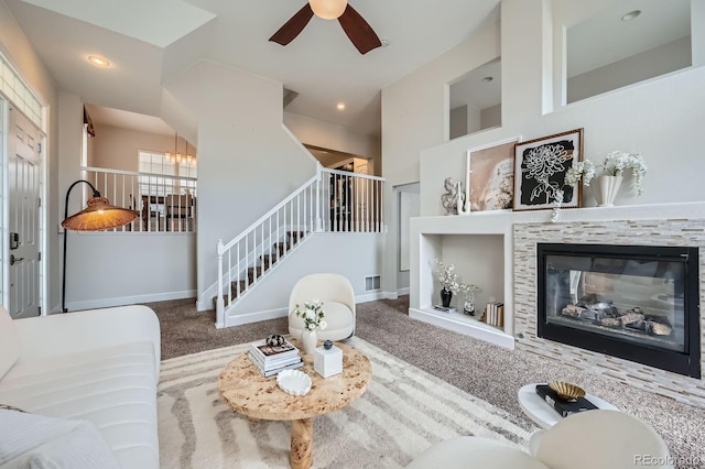 living area with recessed lighting, carpet, baseboards, and a glass covered fireplace