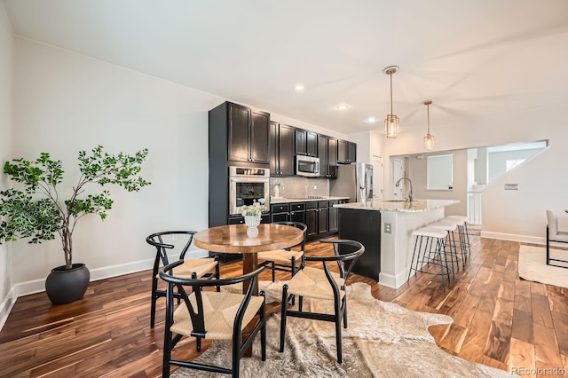 dining room featuring dark wood-type flooring, recessed lighting, and baseboards