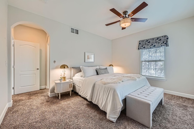 carpeted bedroom featuring arched walkways, visible vents, vaulted ceiling, ceiling fan, and baseboards