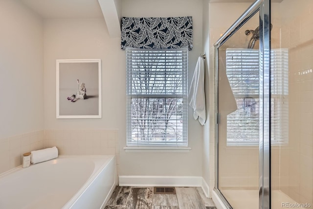 bathroom with visible vents, wood finished floors, a shower stall, and a bath