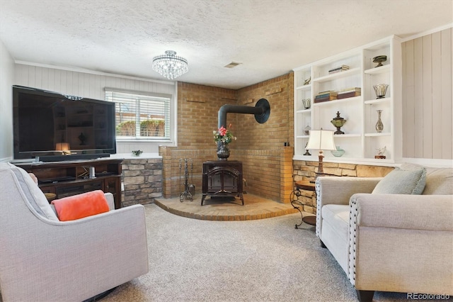 carpeted living room with a wood stove, visible vents, and a textured ceiling