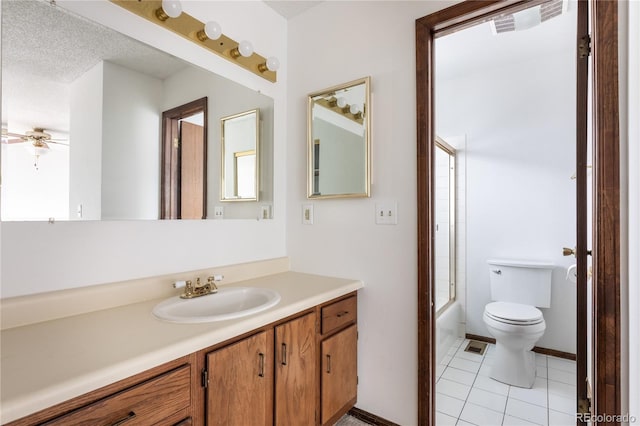 full bathroom featuring toilet, vanity, tile patterned floors, enclosed tub / shower combo, and a textured ceiling