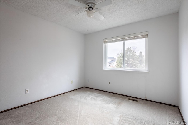 carpeted spare room with ceiling fan and a textured ceiling