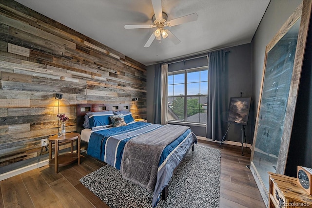 7413 S Quail Cir Unit 1435, Littleton, CO 80127 - bedroom featuring wooden walls, wood finished floors, baseboards, an accent wall, and a ceiling fan