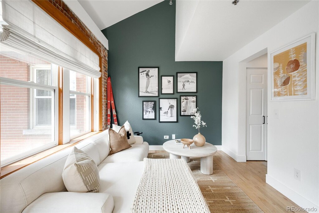 3249 W Fairview Pl Unit 207, Denver, CO 80211 - living area with light wood-style flooring, vaulted ceiling, and baseboards