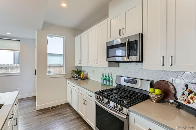 kitchen featuring white cabinets, dark hardwood / wood-style flooring, stainless steel appliances, and tasteful backsplash