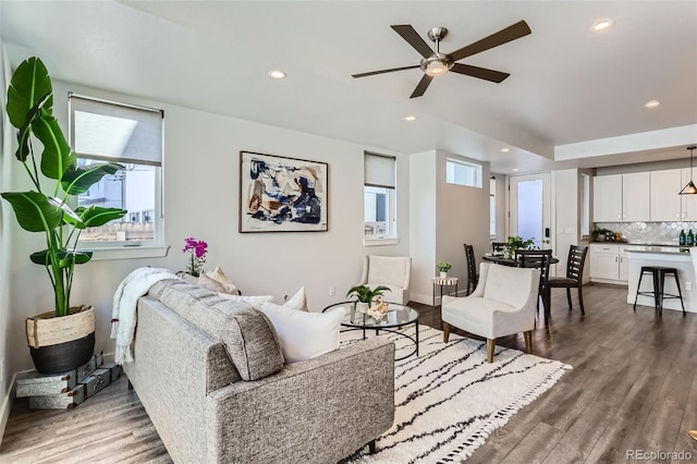 living room featuring wood-type flooring, a wealth of natural light, and ceiling fan