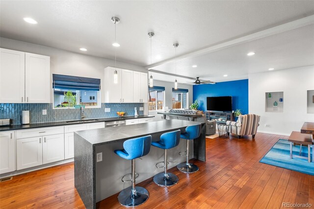 1353 Quaker St, Golden, CO 80401 - kitchen with open floor plan, dark countertops, a kitchen island, hardwood / wood-style floors, and a breakfast bar