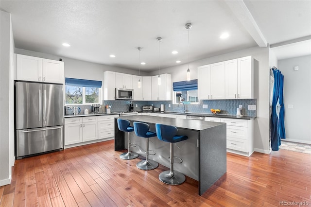 1353 Quaker St, Golden, CO 80401 - kitchen featuring stainless steel appliances, dark countertops, a kitchen breakfast bar, a center island, and tasteful backsplash