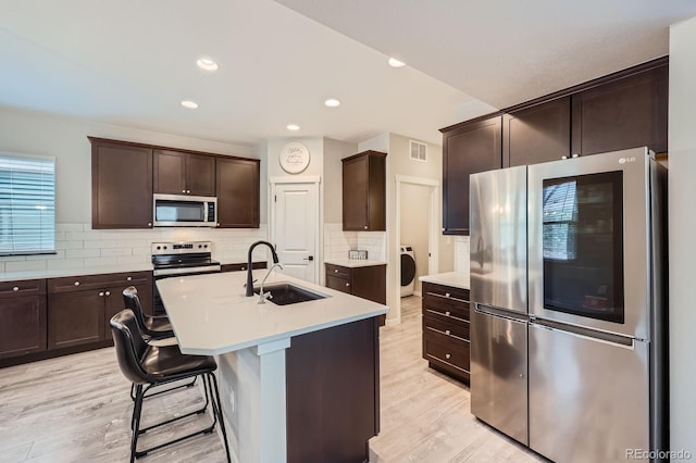 668 Sage Forest Ln, Monument, CO 80132 - kitchen featuring appliances with stainless steel finishes, a sink, dark brown cabinetry, decorative backsplash, and recessed lighting