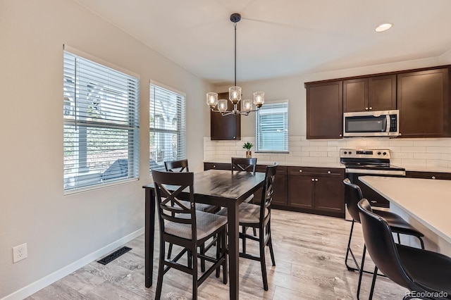 668 Sage Forest Ln, Monument, CO 80132 - dining space with a chandelier, light wood-type flooring, and baseboards