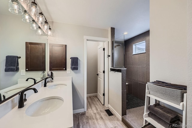 668 Sage Forest Ln, Monument, CO 80132 - full bathroom featuring a walk in shower, wood finished floors, double vanity, and baseboards