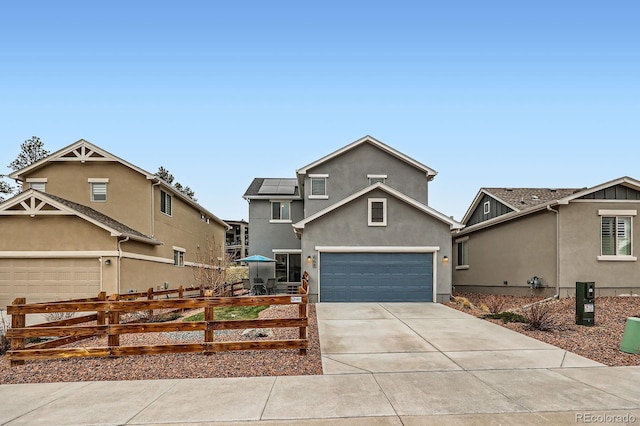 668 Sage Forest Ln, Monument, CO 80132 - traditional home featuring driveway, fence, a garage, stucco siding, and solar panels