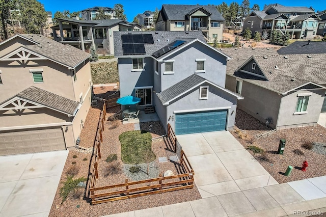 668 Sage Forest Ln, Monument, CO 80132 - view of front of house with a residential view, concrete driveway, fence, solar panels, and a garage