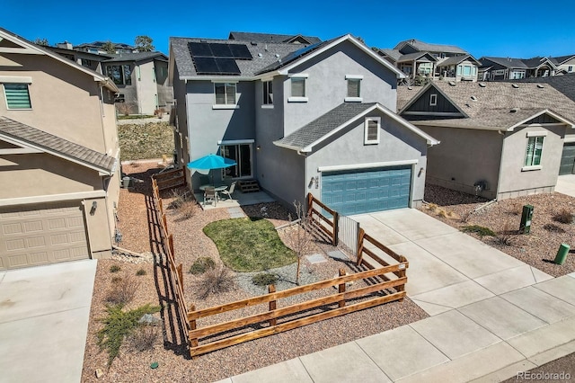 668 Sage Forest Ln, Monument, CO 80132 - view of front of property featuring a residential view, concrete driveway, fence, and roof mounted solar panels