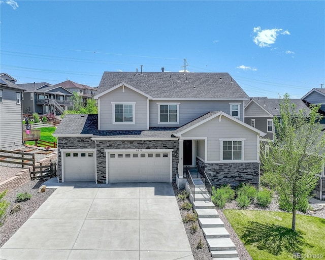 view of front of property featuring fence, driveway, stone siding, a residential view, and a shingled roof