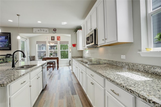 kitchen featuring a sink, appliances with stainless steel finishes, light wood-type flooring, white cabinets, and recessed lighting