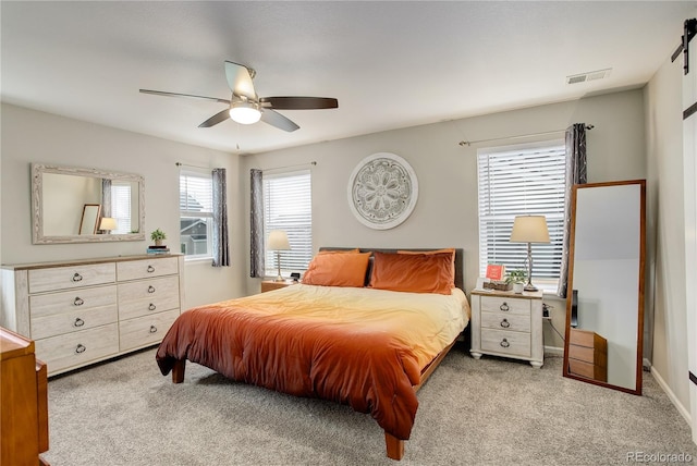 bedroom with carpet floors, a barn door, a ceiling fan, and baseboards