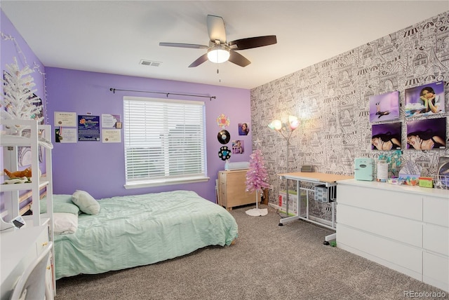 bedroom featuring carpet, an accent wall, and a ceiling fan