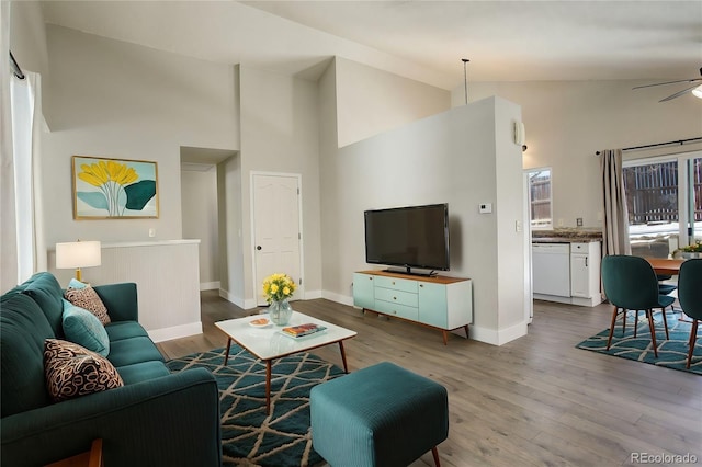 living room with ceiling fan, light hardwood / wood-style floors, and high vaulted ceiling