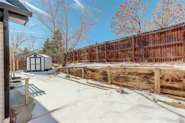 snow covered patio with a storage unit