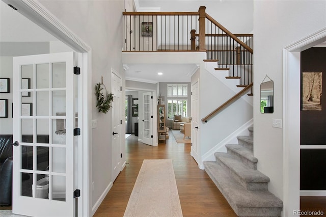 7027 Chestnut Hill St, Highlands Ranch, CO 80130 - foyer entrance with french doors, wood finished floors, stairs, a towering ceiling, and crown molding