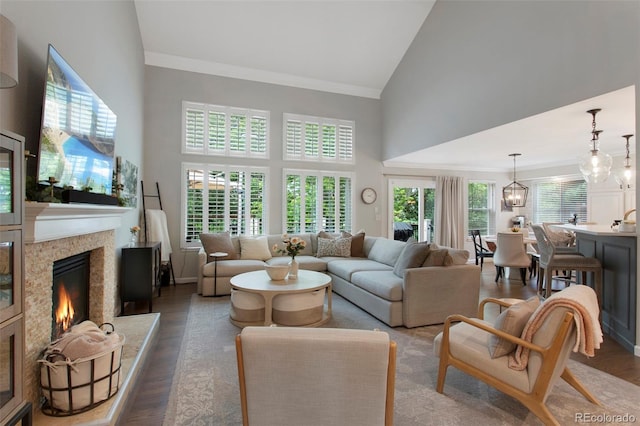 7027 Chestnut Hill St, Highlands Ranch, CO 80130 - living room with high vaulted ceiling, a premium fireplace, wood finished floors, crown molding, and a chandelier