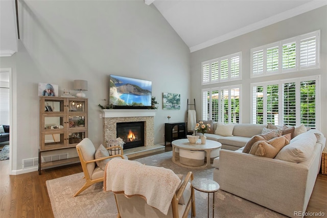 7027 Chestnut Hill St, Highlands Ranch, CO 80130 - living area with high vaulted ceiling, a fireplace, wood finished floors, and crown molding