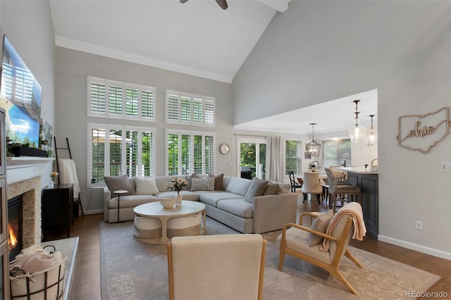 7027 Chestnut Hill St, Highlands Ranch, CO 80130 - living room featuring high vaulted ceiling, dark wood-style flooring, a high end fireplace, ceiling fan, and a chandelier