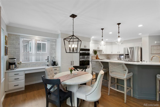 7027 Chestnut Hill St, Highlands Ranch, CO 80130 - dining area featuring crown molding, recessed lighting, dark wood-type flooring, built in desk, and a chandelier