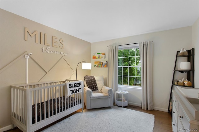 7027 Chestnut Hill St, Highlands Ranch, CO 80130 - bedroom with wood finished floors and a crib