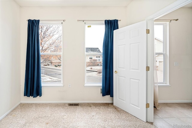 carpeted foyer entrance featuring a healthy amount of sunlight