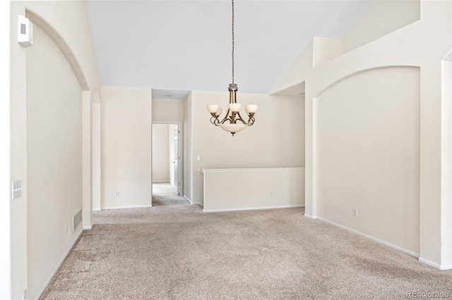 unfurnished dining area featuring an inviting chandelier, light colored carpet, and lofted ceiling