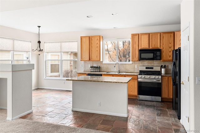 kitchen featuring hanging light fixtures, decorative backsplash, light stone counters, and black appliances