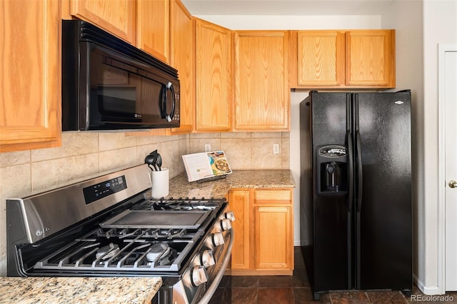 kitchen featuring tasteful backsplash, light stone countertops, and black appliances