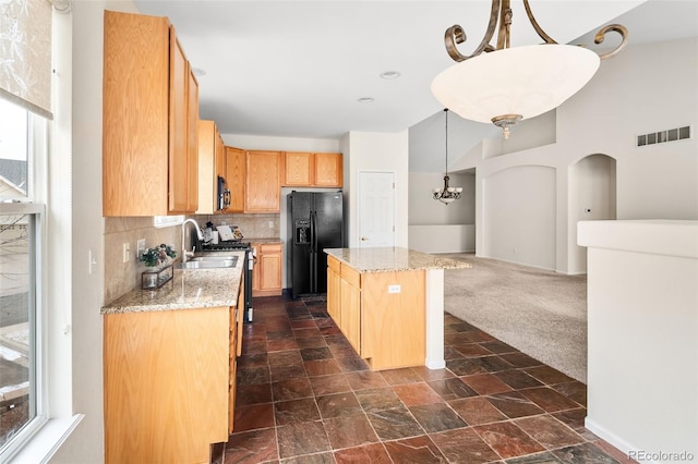 kitchen featuring a kitchen island, decorative light fixtures, tasteful backsplash, dark colored carpet, and black appliances