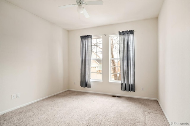 carpeted empty room with ceiling fan and plenty of natural light