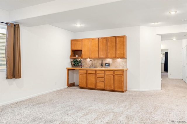 kitchen featuring tasteful backsplash, sink, and light colored carpet