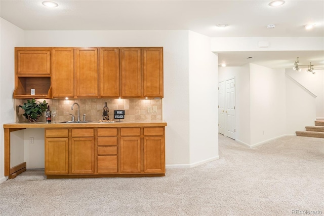 kitchen featuring sink, light carpet, and backsplash