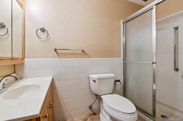585 S Alton Way Unit 4D, Denver, CO 80247 - full bathroom with tile walls, a stall shower, vanity, and a wainscoted wall