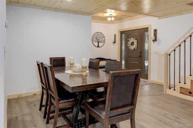 28251 Shadow Mountain Dr, Conifer, CO 80433 - dining space with stairs, wood ceiling, light wood finished floors, and baseboards