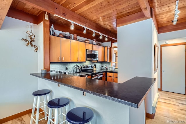 620 Tennis Club Rd Unit 1339, Dillon, CO 80435 - kitchen featuring track lighting, range with electric stovetop, stainless steel microwave, a wood ceiling with exposed beams, and dark countertops