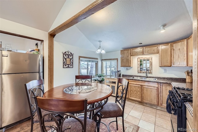 195 Briggs St, Erie, CO 80516 - kitchen with black gas range, a sink, dark countertops, freestanding refrigerator, and lofted ceiling