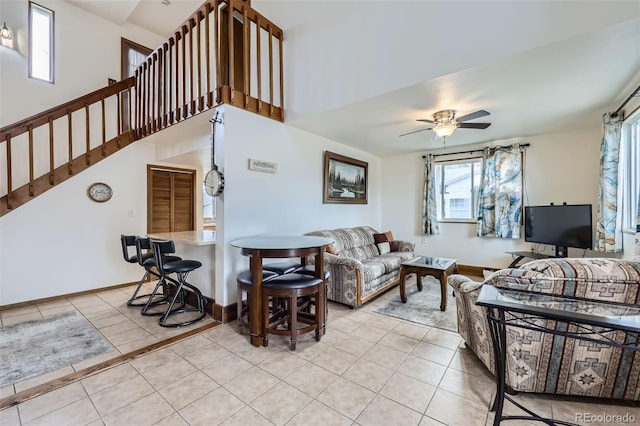 195 Briggs St, Erie, CO 80516 - living area featuring baseboards, stairs, light tile patterned floors, a high ceiling, and a ceiling fan