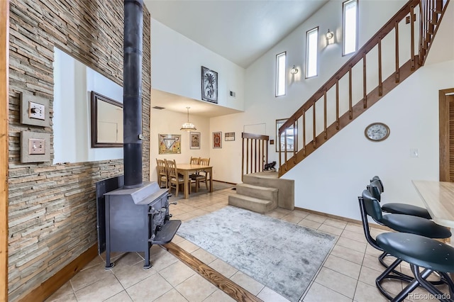 195 Briggs St, Erie, CO 80516 - living area with light tile patterned floors, stairway, a high ceiling, and a wood stove