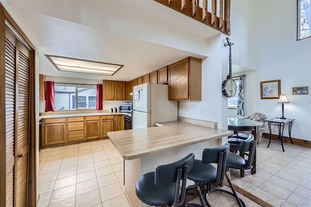 195 Briggs St, Erie, CO 80516 - kitchen with light tile patterned flooring, light countertops, and freestanding refrigerator