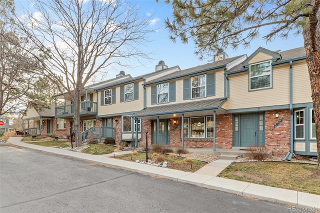 7068 E Briarwood Dr, Centennial, CO 80112 - townhome / multi-family property with brick siding, a chimney, a balcony, a residential view, and a porch
